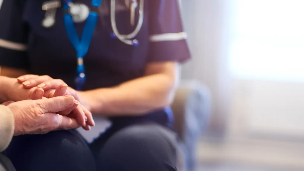Close-up of a doctor interacting with a patient, with a stethoscope visible, suggesting a medical consultation.