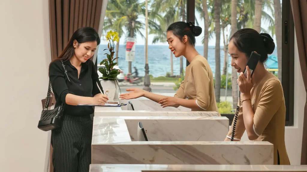 Hotel receptionist assisting a guest at the front desk
